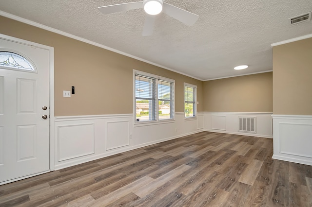 foyer featuring ceiling fan, a textured ceiling, crown molding, and wood-type flooring