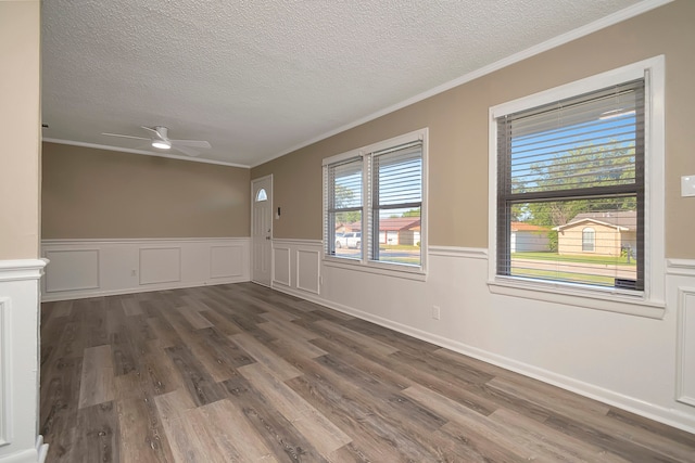 unfurnished room featuring ceiling fan, ornamental molding, a textured ceiling, and dark hardwood / wood-style flooring