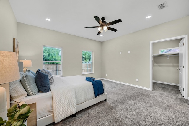 bedroom featuring a spacious closet, carpet floors, ceiling fan, and a closet