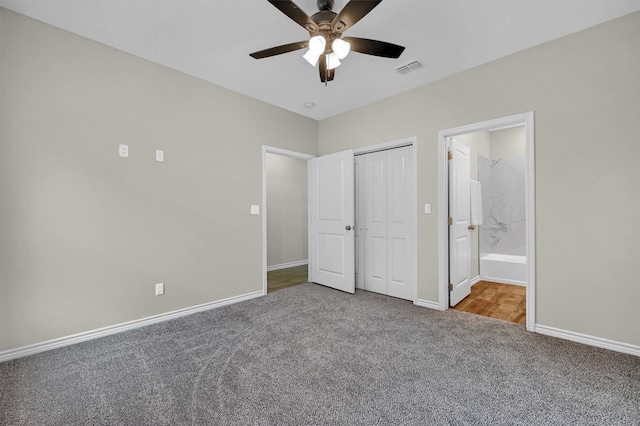 unfurnished bedroom with carpet, ceiling fan, a closet, and connected bathroom