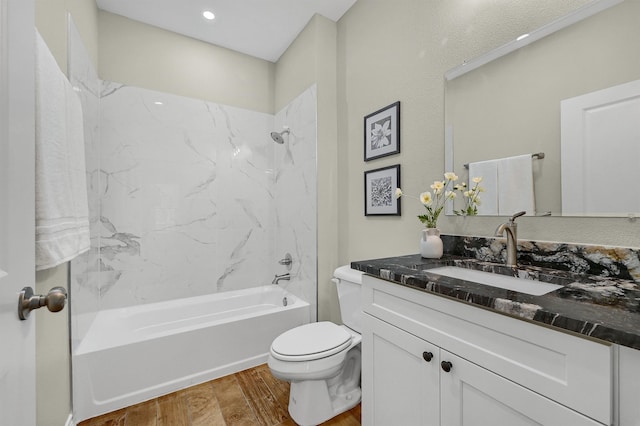 full bathroom featuring hardwood / wood-style flooring, vanity, toilet, and tiled shower / bath combo