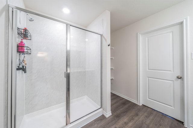 bathroom featuring an enclosed shower and hardwood / wood-style flooring