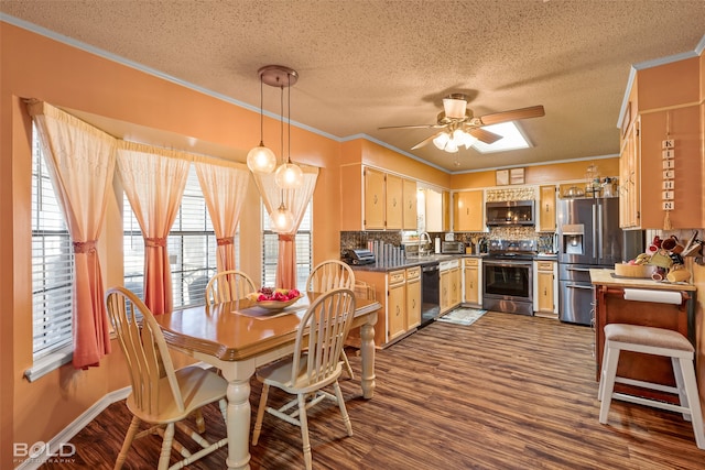 kitchen featuring dark wood-type flooring, tasteful backsplash, stainless steel appliances, crown molding, and ceiling fan