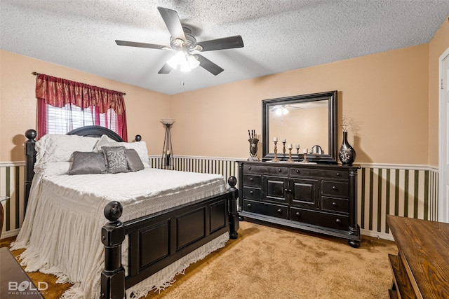 carpeted bedroom with ceiling fan and a textured ceiling