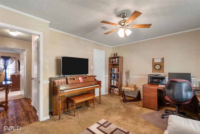 office space featuring crown molding, ceiling fan, carpet floors, and a textured ceiling