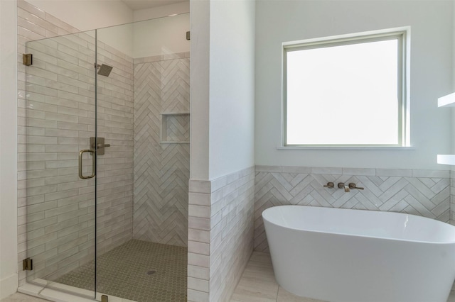 bathroom with tile patterned floors, tile walls, and independent shower and bath