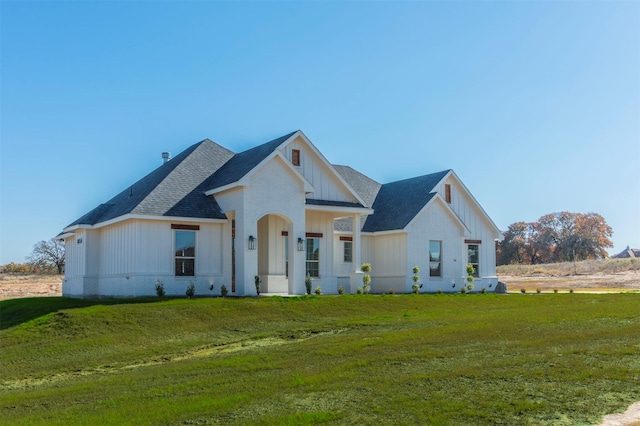 modern farmhouse style home with a front lawn