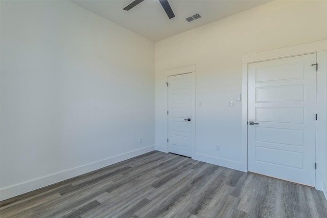 unfurnished bedroom featuring ceiling fan, a closet, and hardwood / wood-style flooring