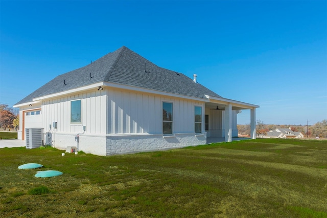 rear view of house with a yard, ceiling fan, and central air condition unit