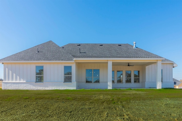 back of house with ceiling fan and a lawn