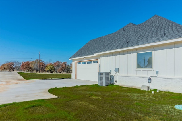 view of side of home featuring a yard, a garage, and central air condition unit