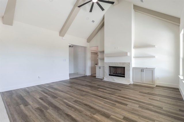 unfurnished living room with ceiling fan, dark hardwood / wood-style flooring, a premium fireplace, and high vaulted ceiling