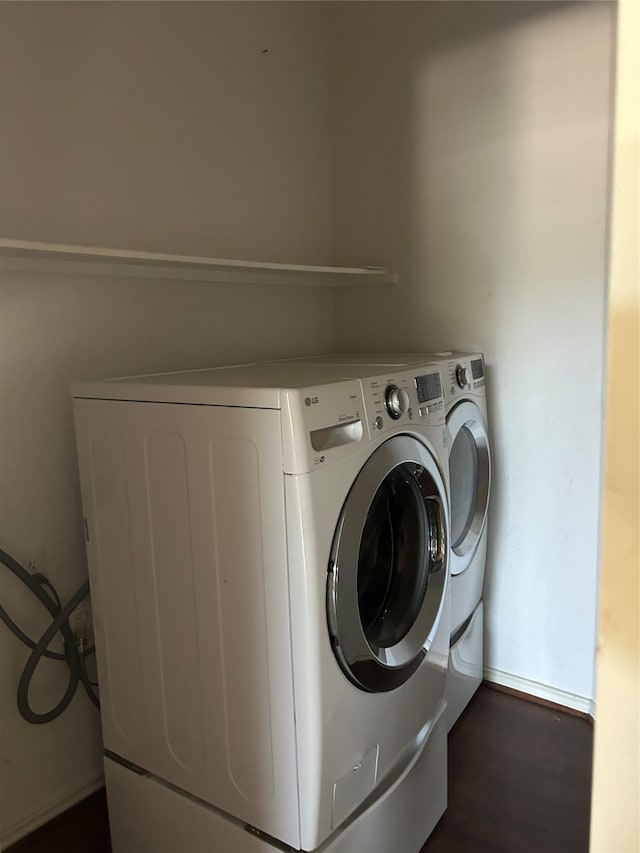 washroom with washer and clothes dryer and dark wood-type flooring