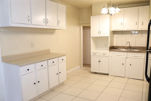 kitchen featuring white cabinets, light tile patterned floors, an inviting chandelier, decorative light fixtures, and sink