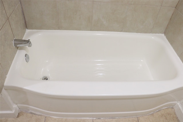 bathroom with tile patterned flooring and a washtub