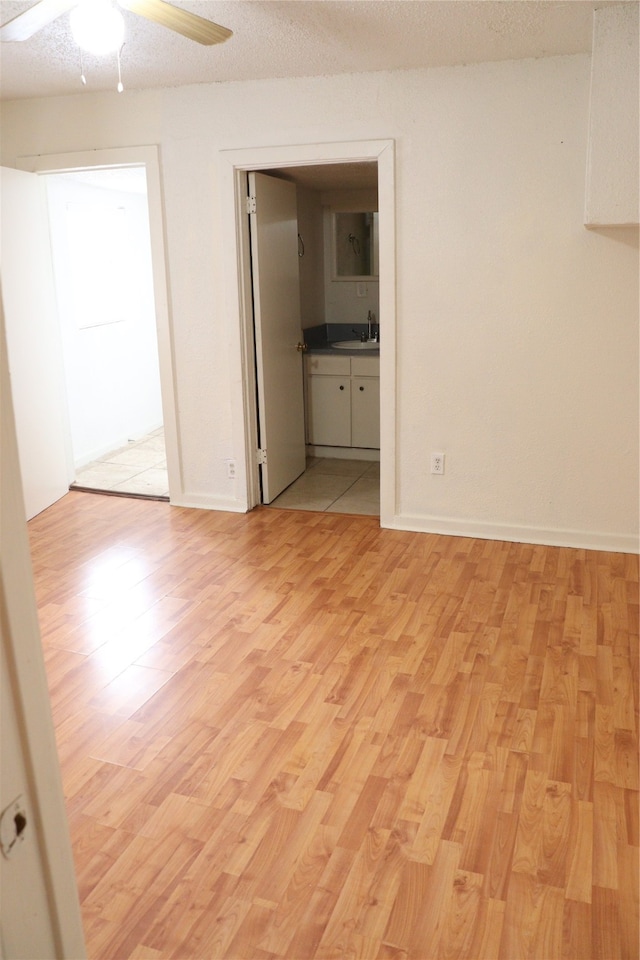 unfurnished room featuring ceiling fan, a textured ceiling, and light hardwood / wood-style flooring