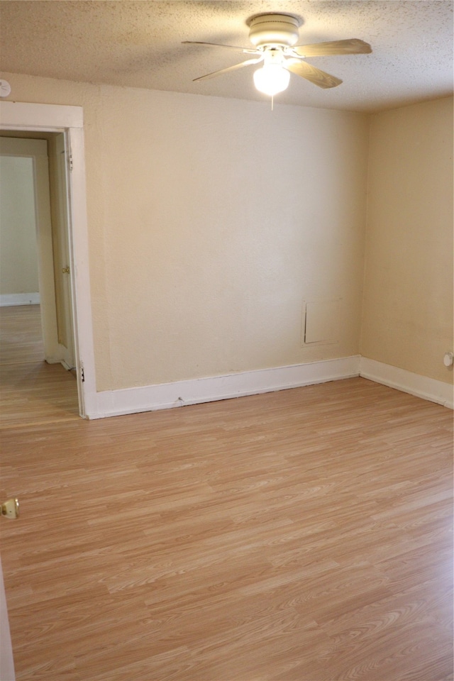 spare room featuring a textured ceiling, light hardwood / wood-style floors, and ceiling fan