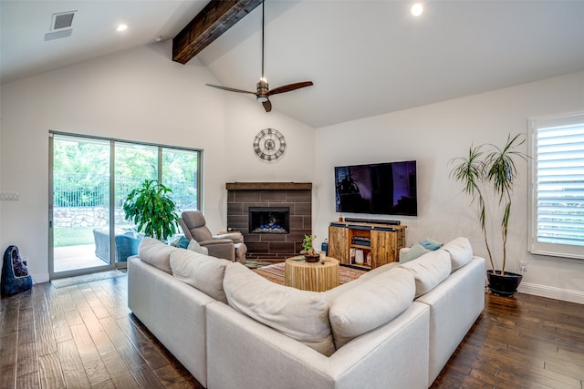 living room with ceiling fan, beamed ceiling, a tiled fireplace, high vaulted ceiling, and dark hardwood / wood-style floors