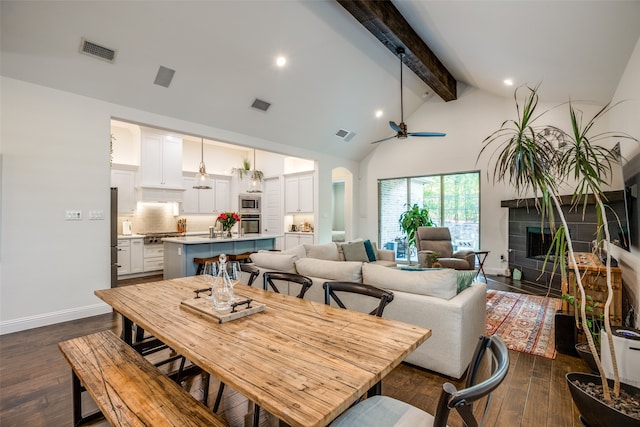 dining room with high vaulted ceiling, dark hardwood / wood-style floors, beamed ceiling, and ceiling fan