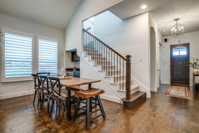 dining room with vaulted ceiling, dark hardwood / wood-style flooring, and a chandelier