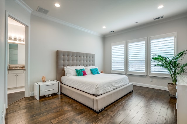 bedroom with connected bathroom, dark wood-type flooring, and crown molding