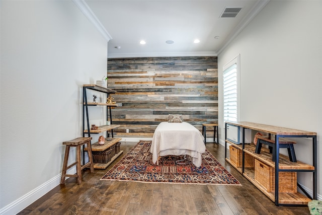 living area with ornamental molding, wood walls, and dark hardwood / wood-style flooring