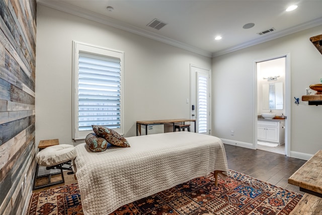 bedroom featuring a fireplace, ornamental molding, ensuite bath, and hardwood / wood-style flooring