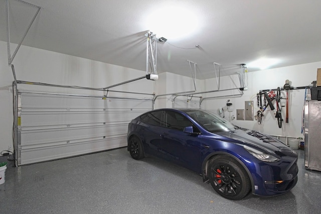 garage with electric panel, a garage door opener, and stainless steel refrigerator