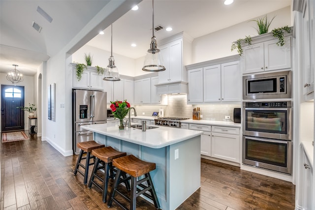 kitchen featuring dark hardwood / wood-style flooring, stainless steel appliances, decorative light fixtures, sink, and a chandelier