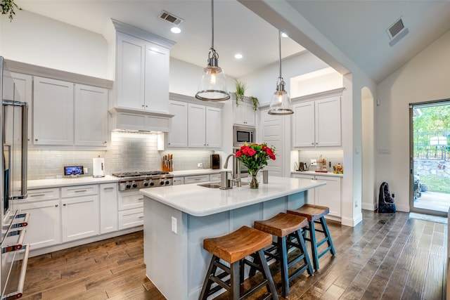 kitchen with a kitchen island with sink, lofted ceiling, dark wood-type flooring, and sink