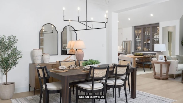 dining space featuring light wood-type flooring and a chandelier