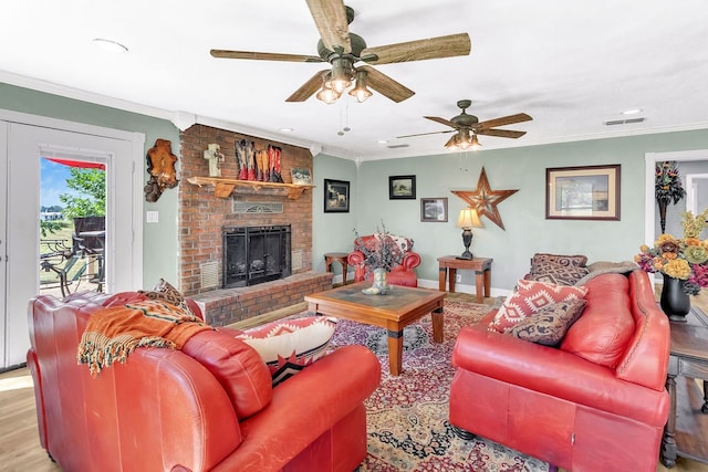 living room featuring ceiling fan, a fireplace, light wood-type flooring, and ornamental molding