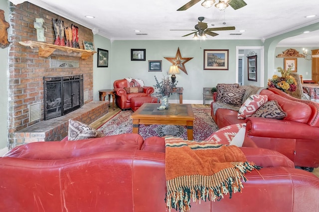 living room with ceiling fan, a fireplace, and crown molding