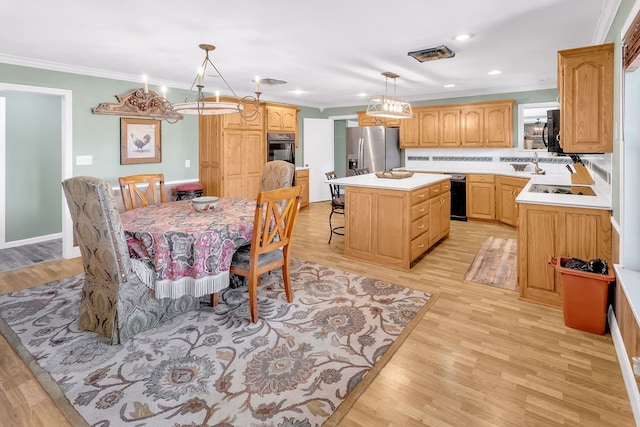 kitchen with decorative light fixtures, appliances with stainless steel finishes, light wood-type flooring, and a center island