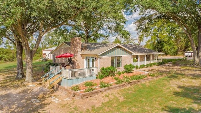 back of property with a yard and a wooden deck