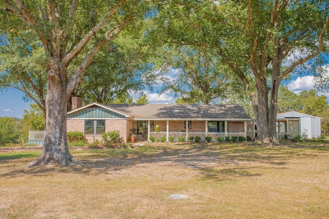 ranch-style home featuring a front lawn and covered porch