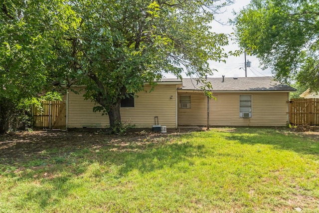 back of house with cooling unit and a yard