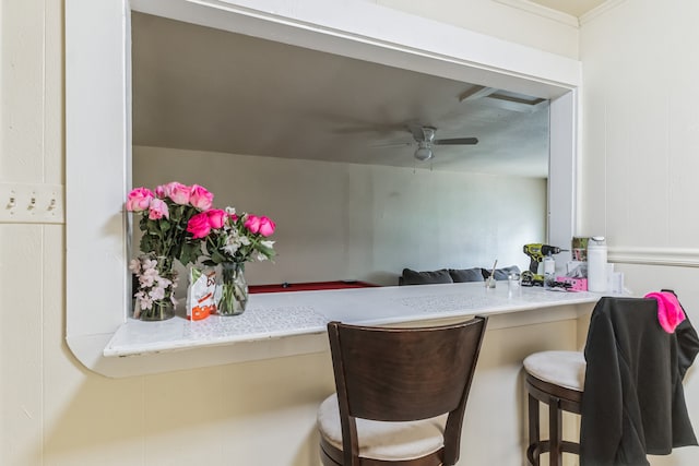 kitchen featuring ceiling fan and a breakfast bar