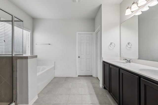 bathroom featuring vanity, a washtub, and tile patterned flooring