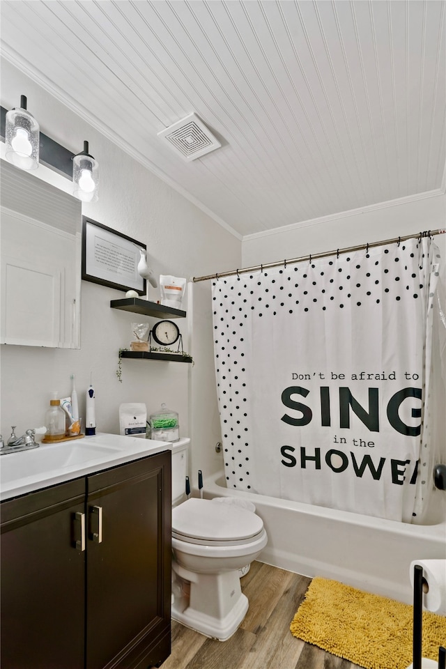 full bathroom with hardwood / wood-style flooring, crown molding, shower / bath combo with shower curtain, vanity, and toilet