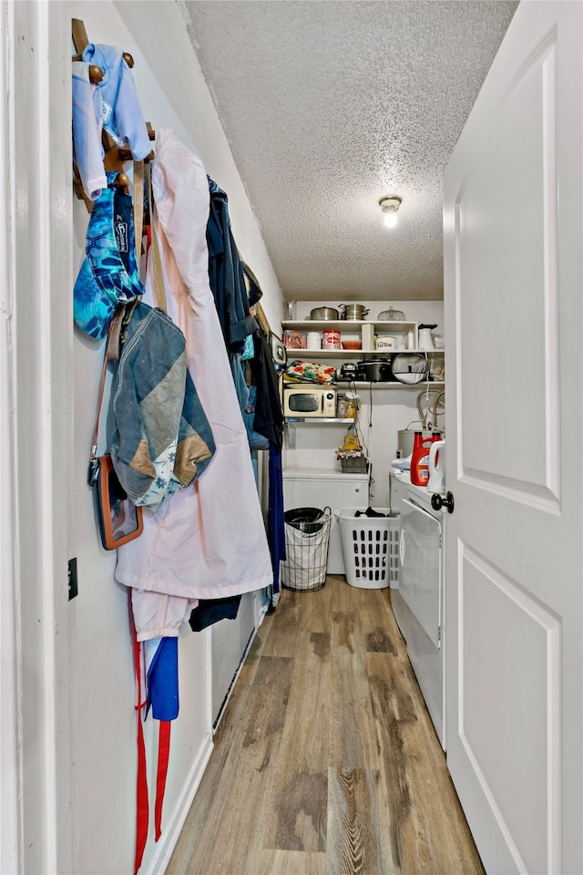 spacious closet featuring light hardwood / wood-style floors and washer and clothes dryer