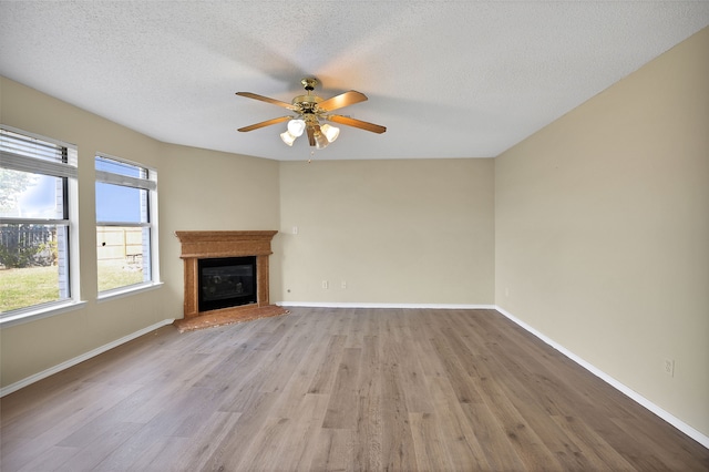 unfurnished living room featuring a textured ceiling, light hardwood / wood-style floors, and ceiling fan