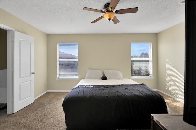 carpeted bedroom with ceiling fan, a textured ceiling, and multiple windows