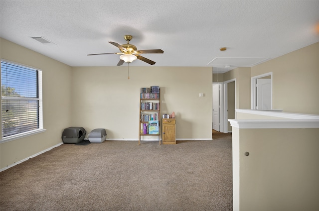 carpeted spare room featuring ceiling fan and a textured ceiling