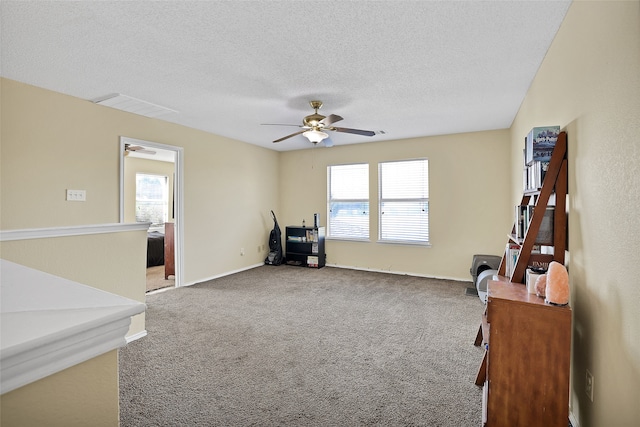 sitting room with carpet floors, a textured ceiling, ceiling fan, and a wealth of natural light