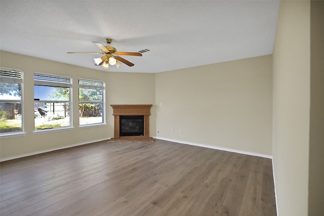 unfurnished living room with wood-type flooring, ceiling fan, and a textured ceiling