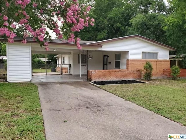 ranch-style house featuring a carport and a front lawn