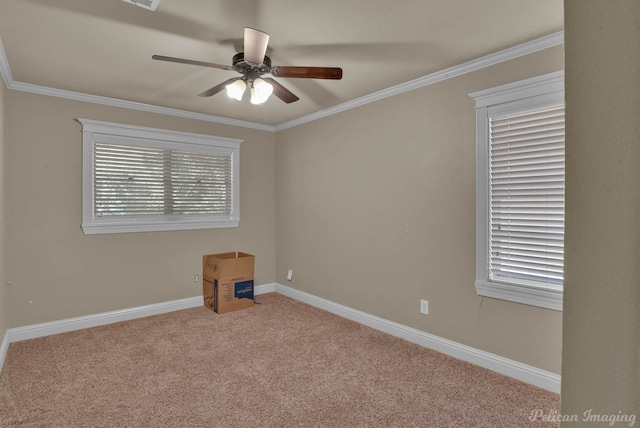 empty room with a healthy amount of sunlight, ornamental molding, ceiling fan, and light colored carpet