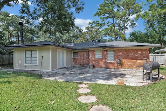 rear view of house featuring a patio and a yard