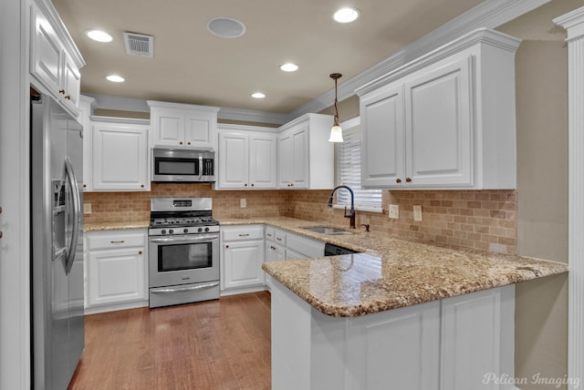 kitchen featuring pendant lighting, white cabinets, sink, kitchen peninsula, and stainless steel appliances